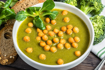 Italian broccoli soup or cream soup on wooden table.