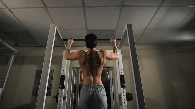 Back view portrait of a muscular man tightening in The Gym's Studio