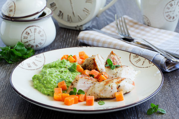 Pieces of chicken with pea puree and pumpkin.