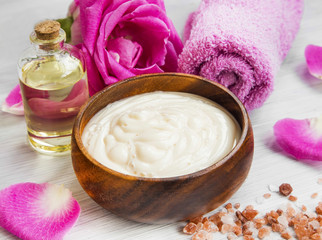 Obraz na płótnie Canvas Spa setting with roses body-lotion and oil, sea salt and cotton
