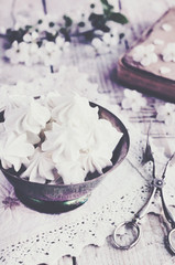 Still life in vintage style with meringue kisses and cherry flowers