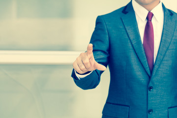 Businessman pushing on a touch screen. vintage color tone