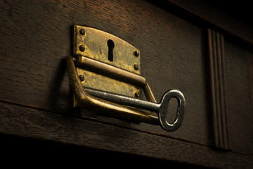 Old lock in a wooden drawer with a vintage key