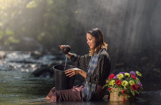 Asian woman in cascade, Thailand.