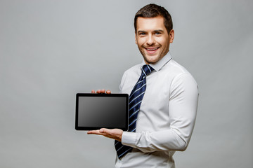 Handsome stylish businessman on grey background