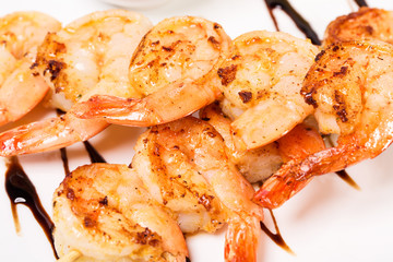 Delicious grilled shrimps on skewers.