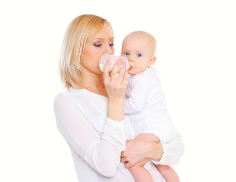 Mother feeding from bottle her baby over white background