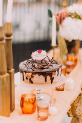Temting chocolate wedding cake on the luxurious oriental wedding table