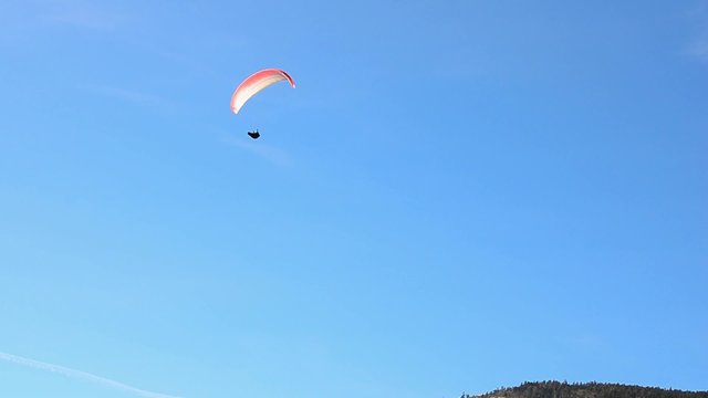 einzelner paragleiter bei schoenem  blauen himmel