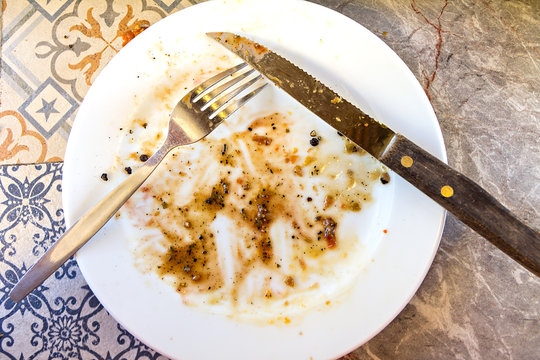 Dirty And Empty Dish With Knife And Fork