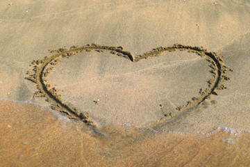 Heart drawn on the beach sand