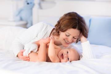 Mother and baby on a white bed