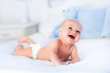 Baby boy on white bed