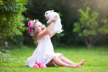 Little girl playing with real rabbit