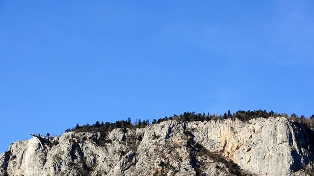 viele paragleiter schweben bei hoher felswand