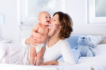 Mother and baby on a white bed