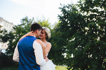 Fototapeta premium Beautiful wedding couple hugging in the park