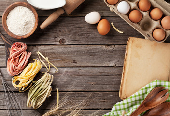 Kitchen table with cookbook, utensils and ingredients