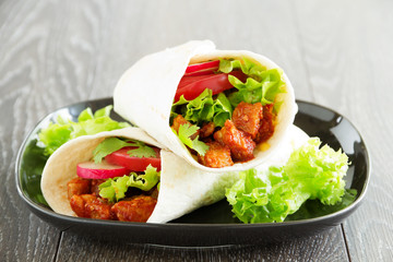 Burrito with pork and tomatoes.