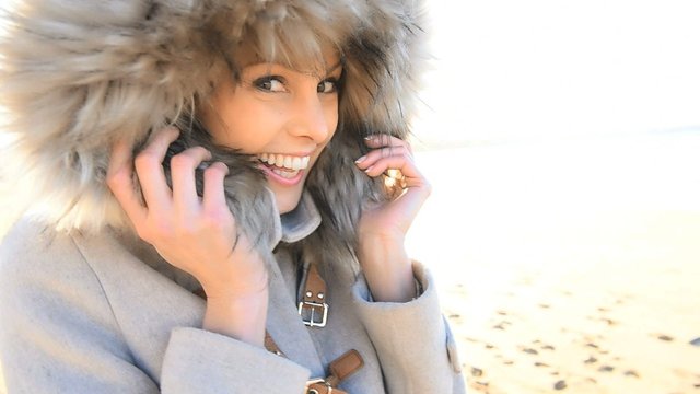 Cheerful attractive woman with winter coat and fur hood