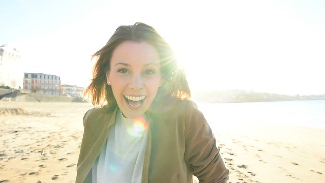 Cheerful beautiful woman walking on the beach