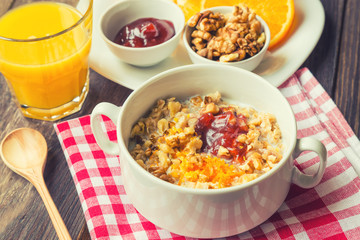 Oatmeal with walnuts, orange peel and jam for breakfast