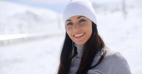 Fototapeten Extremsportarten Gorgeous young woman in winter fashion in a snowy landscape looking at the camera with a lovely warm friendly smile  with copy space  © Dash
