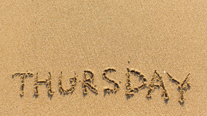 Thursday - word drawn on the bright yellow beach sand.
