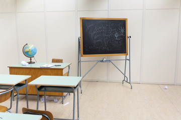 desks and blackboard in classroom at school