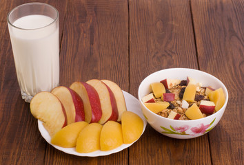 muesli with peach, apple and a glass of milk 