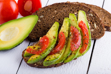 Tasty avocado sandwich with tomato and seasoning for slimming.