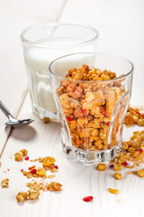 Granola, milk and honey in a glass.