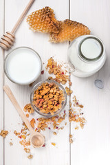 Granola, milk and honey in a glass.