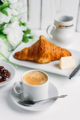 Breakfast with coffee, croissant and strawberry jam