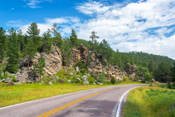 Road in Custer State Park passing beautiful rock formations in South Dakota