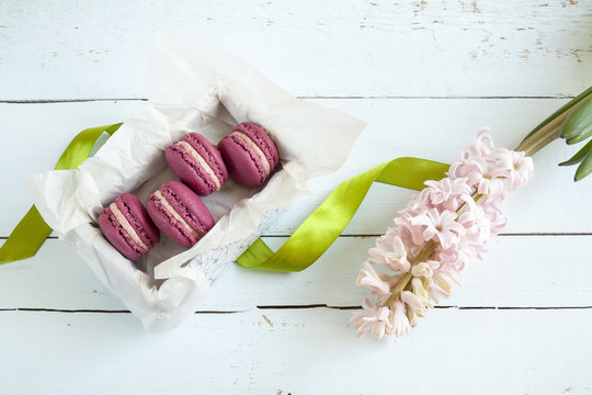 Sweet crimson french macaroons with box and mint on  light dyed wooden background