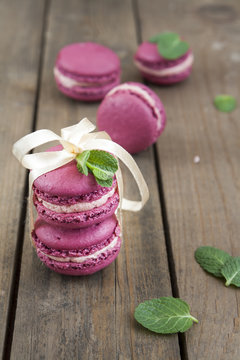 Sweet crimson french macaroons tied with ribbon on dark wooden background