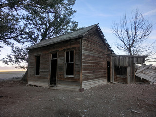 Abandoned shack in prairie with blue sky - landscape color photo