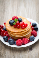Stack of pancakes with blueberry and fresh berry.