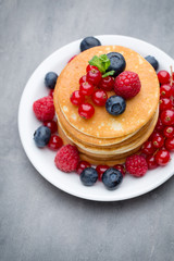 Stack of pancakes with blueberry and fresh berry.