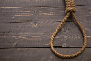Loop hempen ropeon on a dark wood tables background. Classic loop knot on grunge wooden background