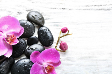 Fototapeta na wymiar Beautiful composition of orchid and pebbles on white wooden background, copy space