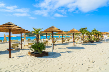 Umbrellas and sunbeds on sandy Villasimius beach, Sardinia island, Italy