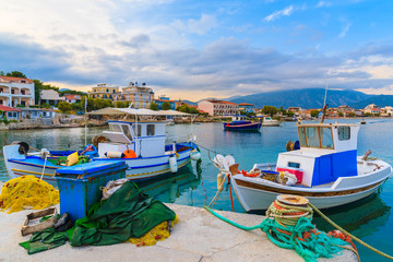 Fototapeta na wymiar Colourful Greek fishing boats mooring in port at sunset time on Samos island, Greece