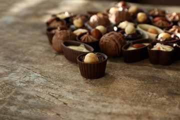 Delicious chocolate candies on wooden background, close up