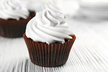 White cupcakes on wooden table