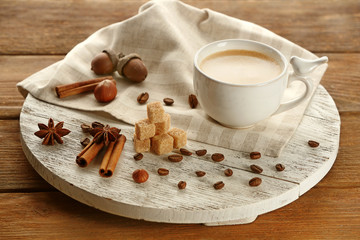 Fototapeta na wymiar Cup of coffee with sugar and cinnamon on white wooden mat