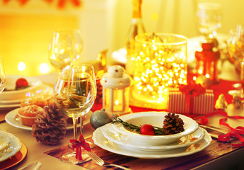 Christmas table setting with holiday decorations on fireplace background
