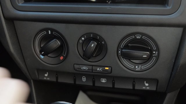 Man's hand push automatic air recirculation button in the car. Automobile. 