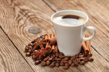cup with coffee beans and spices anise star